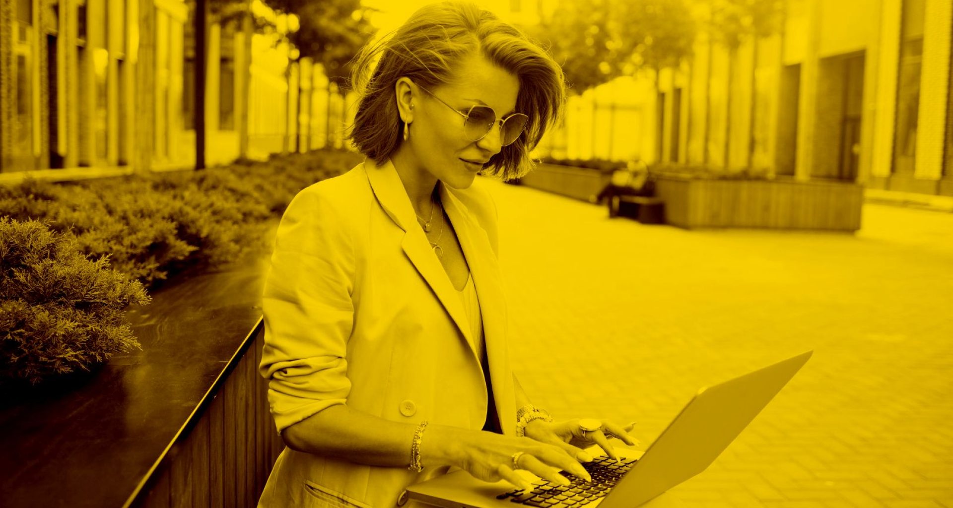 Unternehmerin arbeitet auf einer Sitzbank mobil von der maja.cloud