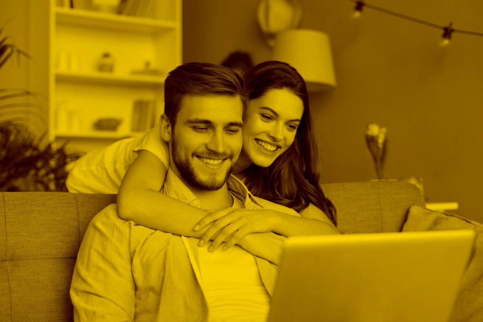 Junges Paar auf der Couch vor dem Laptop