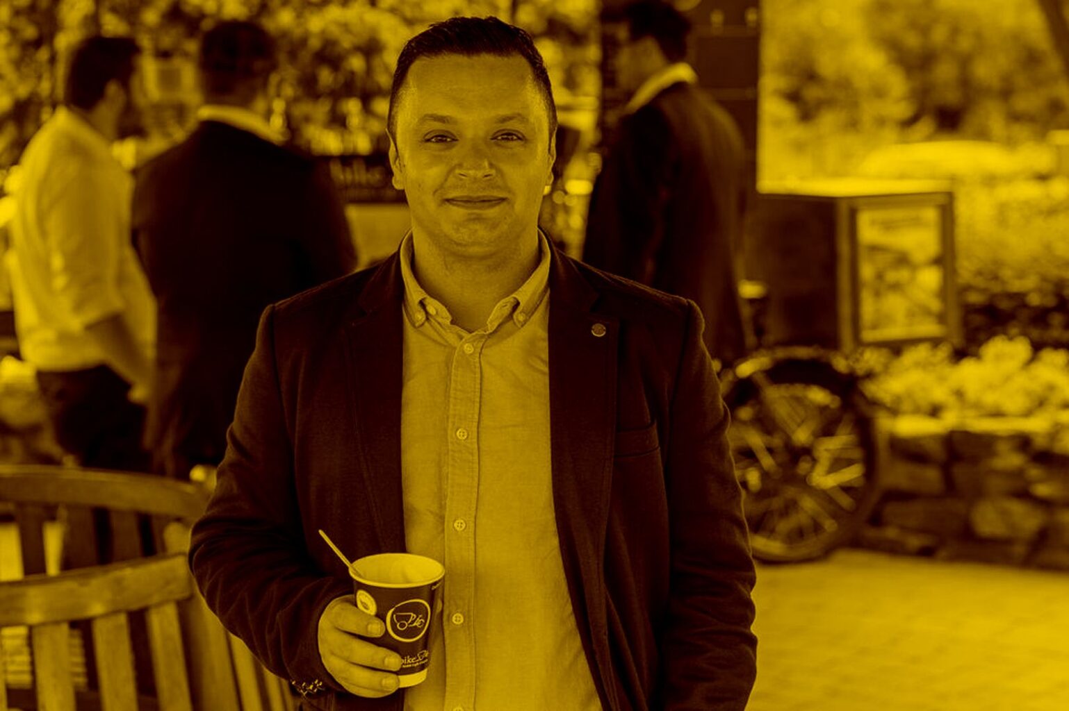 Junger Mann steht mit Kaffee in der Hand