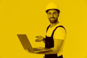 Handwerker steht mit einem Laptop in der Hand