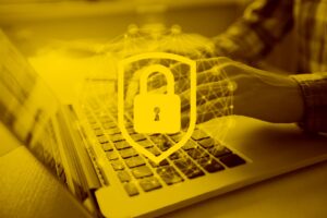 Hand am Laptop schützt sein Onlineshop mit Shop-Security