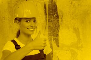 Handwerkerin lächelt und hält den Daumen hoch